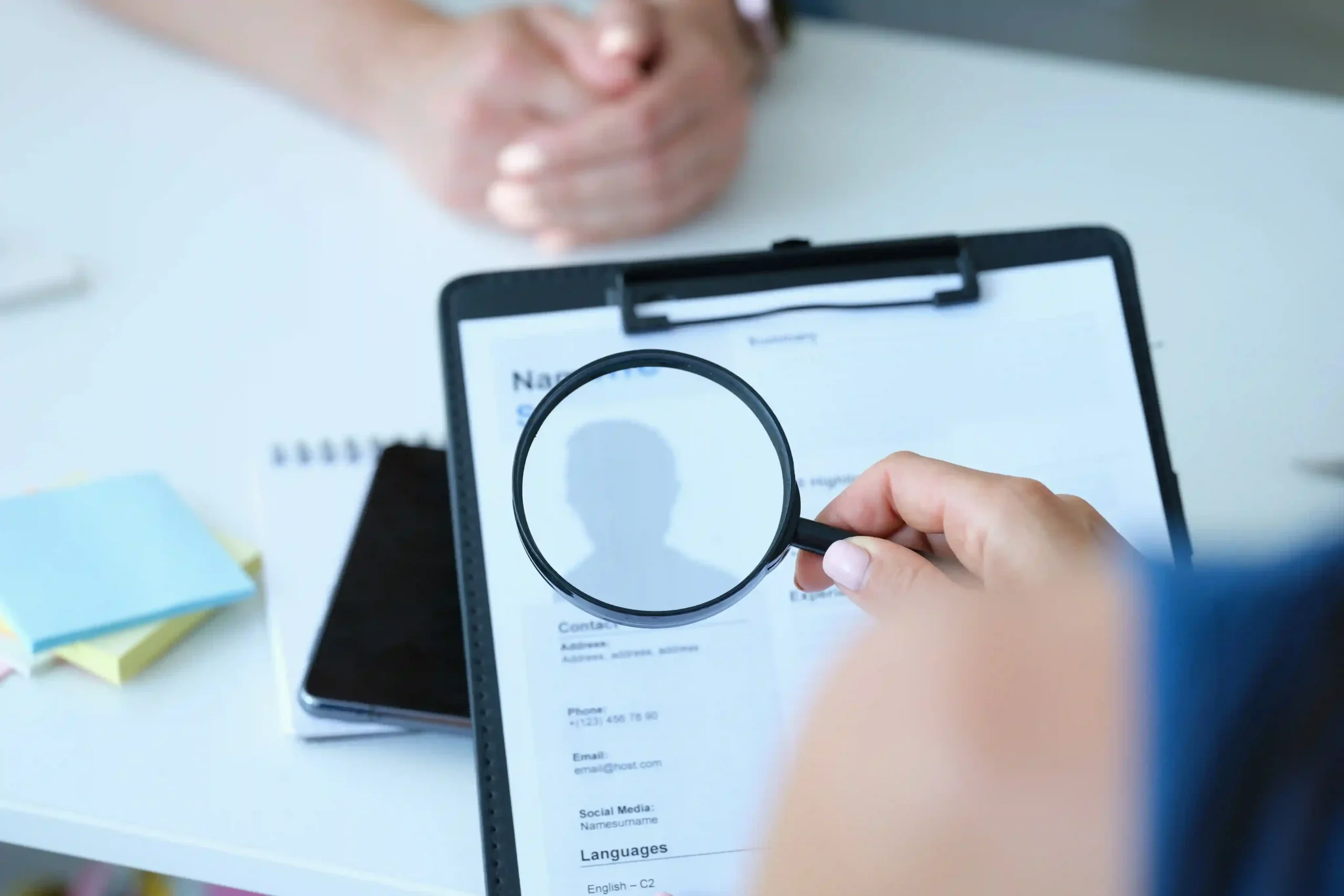 employee-examines-resume-application-form-magnifying-glass_11zon
